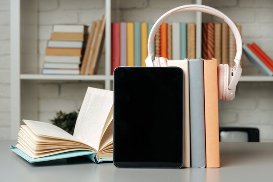 Digital tablet with stacked books in library
