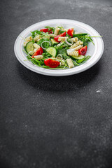 pasta salad fusilli pasta, cucumber, tomato, green lettuce, onion healthy eating cooking appetizer meal food snack on the table copy space food background rustic top view