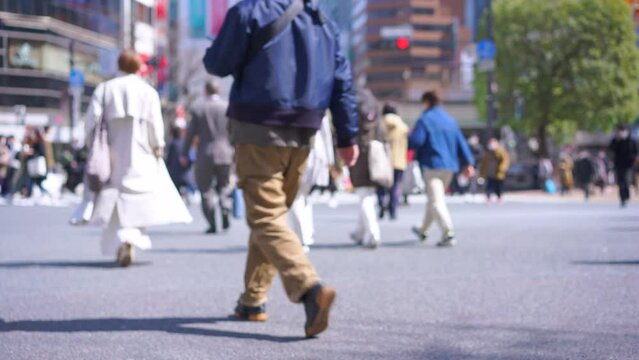 Large crowds of people walking Shibuya's scramble crossing [low angle]
