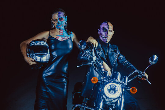 Photo of a demonic couple of zombie bikers on night background.