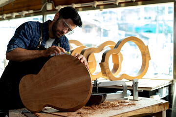 Luthier Sanding Acoustic Guitar Body in Workshop
