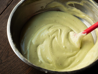 pandan chiffon cake batter in mixing bowl with spatula