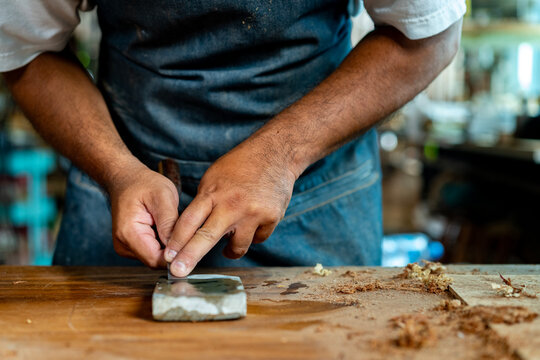 Closeup of Carpenter's Hand Sharpening Chisel