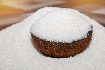 Sugar in a wooden bowl on background