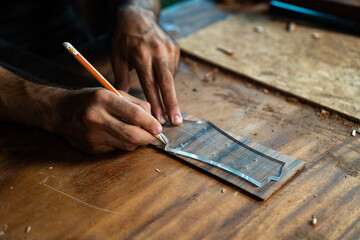 Guitar luthier crafting headstock from acrylic pattern