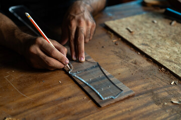 Guitar luthier crafting headstock from acrylic pattern