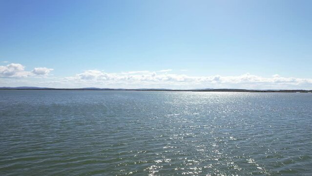 Flying above calm waters of Wooloweyah Lagoon. Coastal estuarine lagoon in New South Wales, Australia. low aerial
