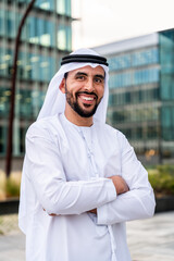 Arab middle-eastern man wearing emirati kandora traditional clothing in the city - Arabian muslim businessman strolling in urban business centre.