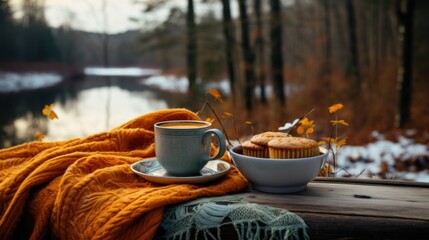 A cup of coffee next to a muffin on a table