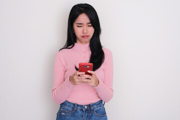 Asian young woman showing sad expression when typing on her phone