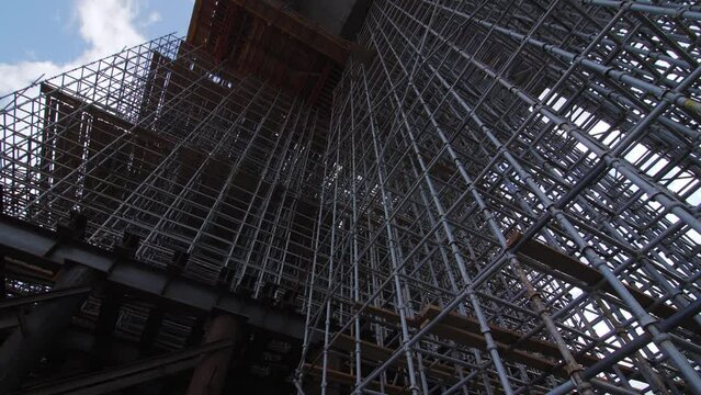 Metal reinforcement carcass under future traffic bridge. Building equipment at transports overpass construction site. Steel frame tower