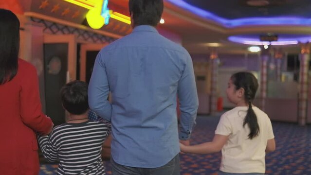 Asian family audiences come to movies when theater opens and cinema shows, enjoy walking together in the hall, public indoor entertainment lifestyle with film art shows, and happy and cheerful people.