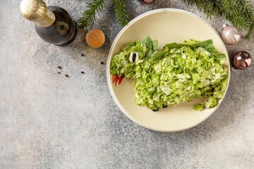 New 2024 - the year of a green dragon, creative design for party. Layered Salad with mushrooms, beans and сhinese cabbage in shape of dragon as symbol of chinese new year. View from above. Copy space.
