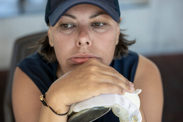 Disappointed Golfer with a Cap Leaning on Her Golf Club in a Sunny Day in Switzerland.