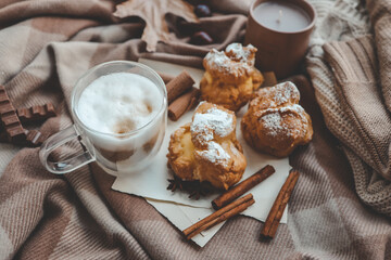 Cozy morning composition, cup of coffee, custard cakes and candle