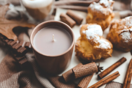 Cozy morning composition, cup of coffee, custard cakes and candle