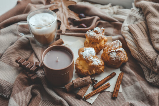 Cozy morning composition, cup of coffee, custard cakes and candle