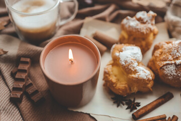 Burning candle with the smell of chocolate and cinnamon in a cozy home interior