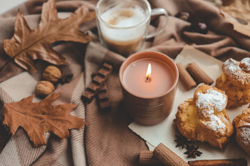 Burning candle with the smell of chocolate and cinnamon in a cozy home interior - obrazy, fototapety, plakaty