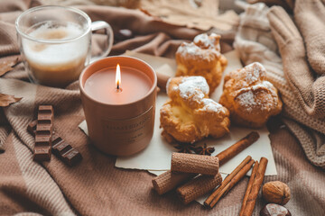Burning candle with the smell of chocolate and cinnamon in a cozy home interior