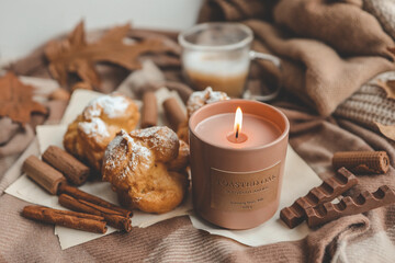 Burning candle with the smell of chocolate and cinnamon in a cozy home interior