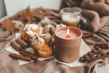 Burning candle with the smell of chocolate and cinnamon in a cozy home interior