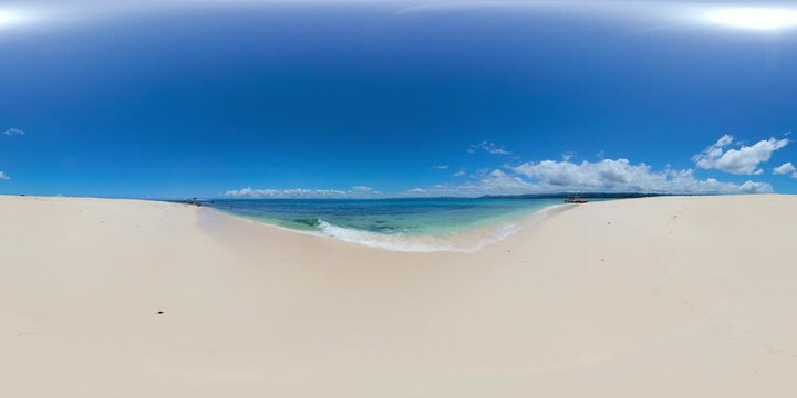 Waves over sandy beach, boat floating over clear ocean water in Naked Island. Surigao del Sur, Philippines. VR 360.