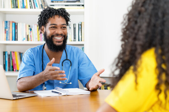 Laughing african american male nurse talking with female patient