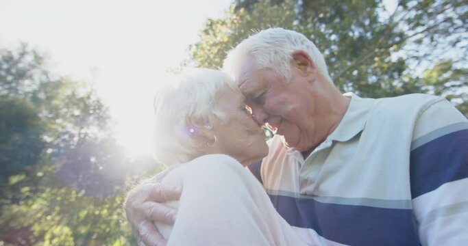 Happy senior caucasian couple embracing in sunny garden, slow motion