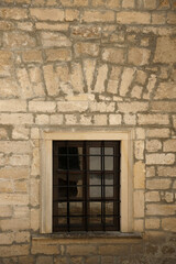 Very old window in brick stone wall of castle or fortress of 18th century. Full frame wall with window