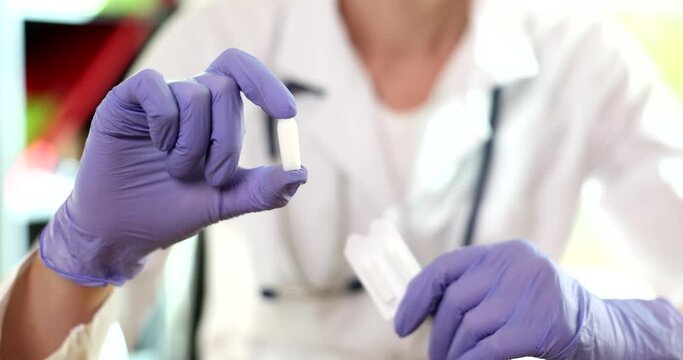 Gloved doctor holds suppositories for anal or vaginal use. Medical candles for treatment of thrush