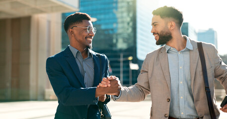 Outdoor, men and walking with business people, handshake and planning with smartphone, smile and hug. Staff, city and coworkers with feedback, speaking and cooperation with professional and talking © N F/peopleimages.com