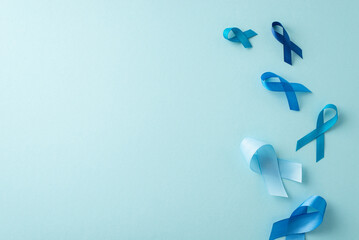 Men's health awareness visual. Overhead shot of flow of prostate cancer emblems - blue ribbons on a pastel blue surface with space for text or advertisements