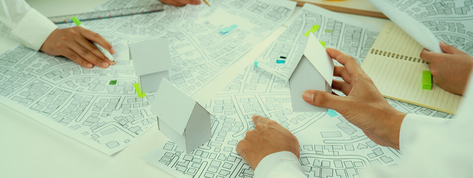 Worker, architect and engineer work on real estate construction project oratory planning with cartography and cadastral map of urban town area to guide to construction developer business plan of city