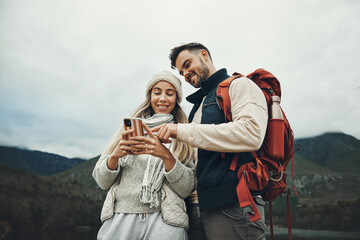 Couple, phone and travel in nature or mountains with hiking information, social media or check for direction on journey. Happy people trekking in backpack, mobile chat or search for outdoor location