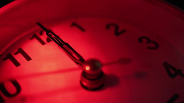 The clock shows the mystical time of 00:00. Midnight. Red light. It's 12 o'clock now, the dark forces are not asleep. Close-up.