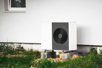 Outdoor Air Conditioner Compressor. Sustainable and Reliable Cooling and heating Solution for Homes. Air heat pumps beside a house.
