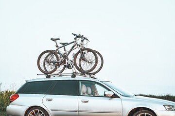 Outdoor Adventure Awaits. Family Car with Bicycles Mounted on Roof Rack. A vehicle with top mounted bikes.