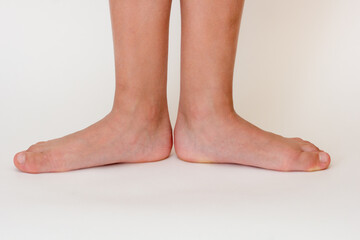 Cropped barefoot child legs on white background. 