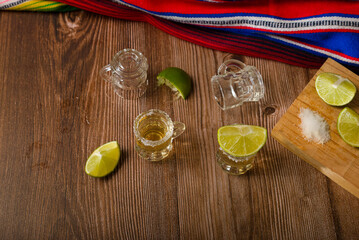 Tequila shots with salt and lime on a bar table. Shots of tequila and typical mexican elements.