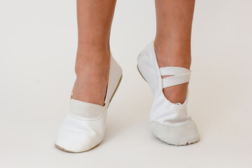 Cropped child legs in different ballet shoes with lifted heels in on white background. Concept right ballet shoes © Tatiana Foxy