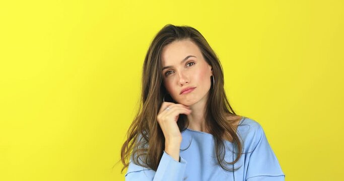 Pensive puzzled young girl thinking isolated on yellow background. Looking aside up put hand prop up on chin, finger on lips. Thoughtful woman thinks deeply chooses or ponders plan, not sure, not know