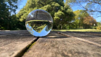公園のテーブルにある透明な水晶ガラスボールの風景