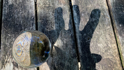 公園のテーブルにある水晶ガラスボールと手の影の様子
