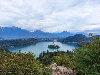 Fototapeta na wymiar view to the island on lake Bled and dark blue mountains. Slovenia.