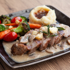 Pork shoulder steak with mushroom sauce, mashed potatoes and grilled vegetable