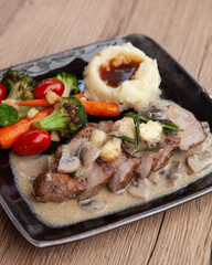 Pork shoulder steak with mushroom sauce, mashed potatoes and grilled vegetable