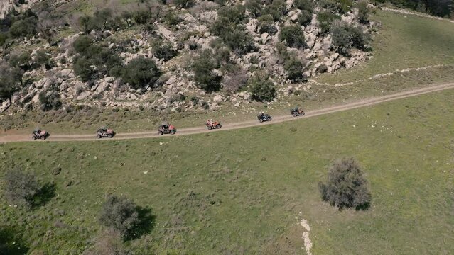 A group of ATV buggies driving a path through the hills of Greece.