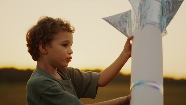 Portrait Of Little Boy Playing With Handmade Toy Rocket Outdoors In Summer, Imagination And Dream