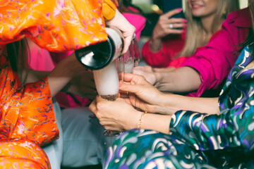 fashionable girls celebrate the new year in a limousine and drink champagne
